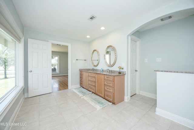 full bathroom with visible vents, a sink, baseboards, and double vanity