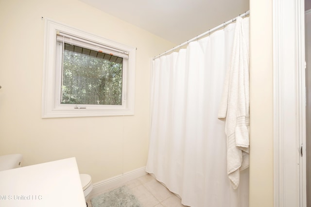 full bath with toilet, tile patterned floors, and baseboards