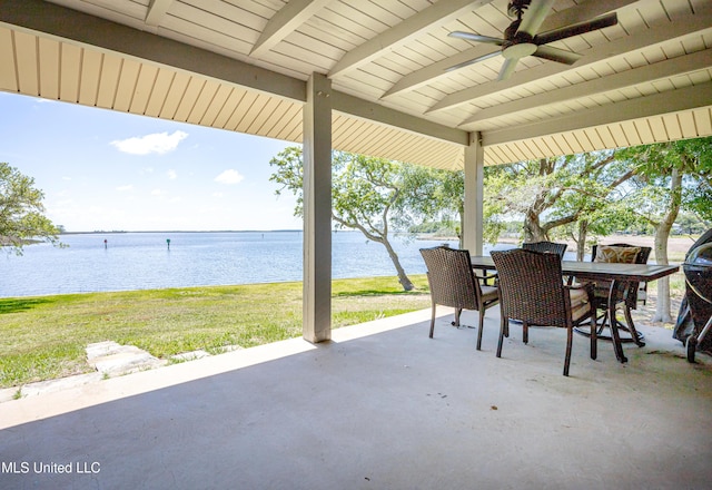 view of patio / terrace with a water view, a ceiling fan, and outdoor dining area