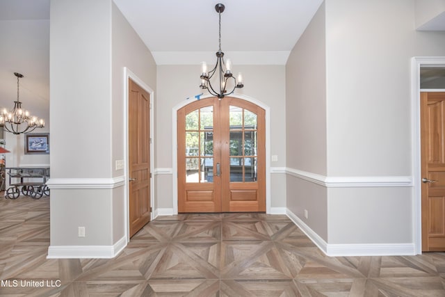 entryway with baseboards, french doors, and a chandelier