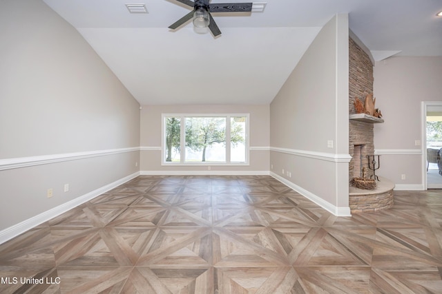 empty room with visible vents, a fireplace, baseboards, ceiling fan, and vaulted ceiling