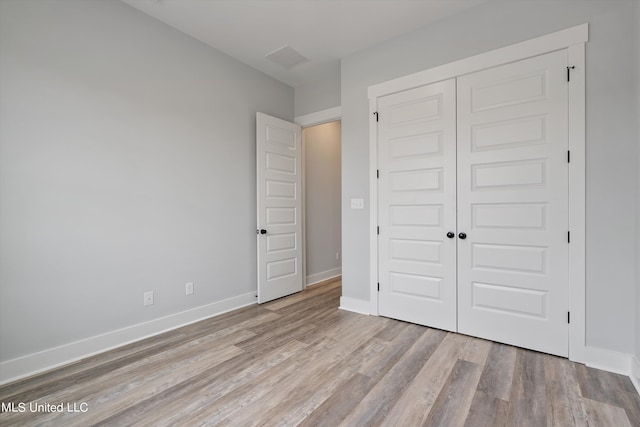 unfurnished bedroom with a closet and light wood-type flooring