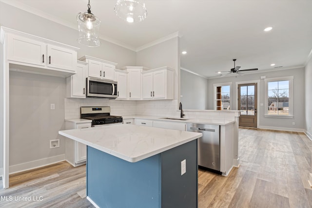 kitchen with a kitchen island, kitchen peninsula, sink, pendant lighting, and appliances with stainless steel finishes