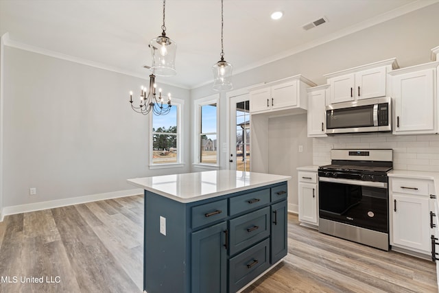 kitchen featuring tasteful backsplash, white cabinetry, light hardwood / wood-style floors, stainless steel appliances, and decorative light fixtures