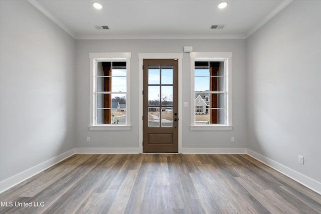 doorway with crown molding and hardwood / wood-style flooring