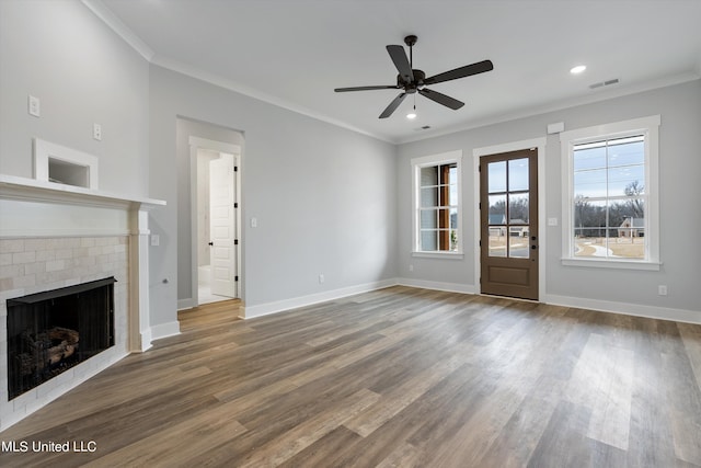 unfurnished living room featuring crown molding, hardwood / wood-style floors, ceiling fan, and a brick fireplace