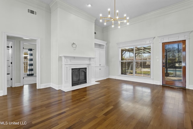 unfurnished living room featuring dark hardwood / wood-style floors, a high ceiling, a chandelier, and ornamental molding