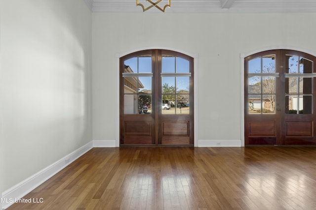 foyer entrance with wood-type flooring, crown molding, and french doors