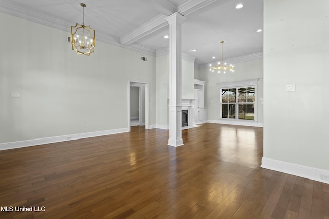 unfurnished living room with an inviting chandelier, ornate columns, dark wood-type flooring, crown molding, and beam ceiling