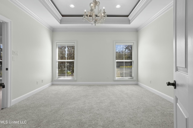 carpeted spare room featuring a tray ceiling, crown molding, and a notable chandelier