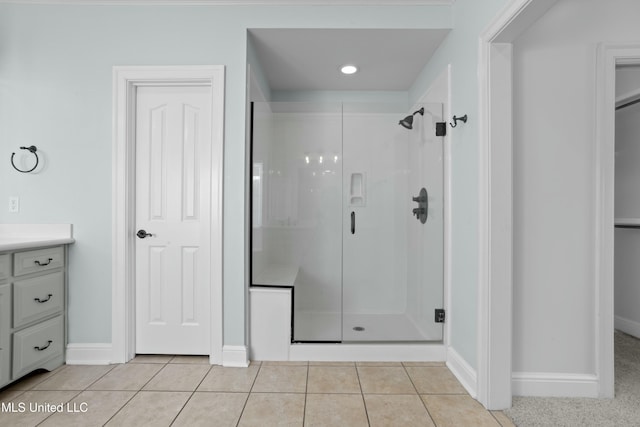 bathroom with walk in shower, vanity, and tile patterned flooring