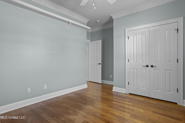 unfurnished bedroom featuring ceiling fan, a closet, ornamental molding, and hardwood / wood-style flooring