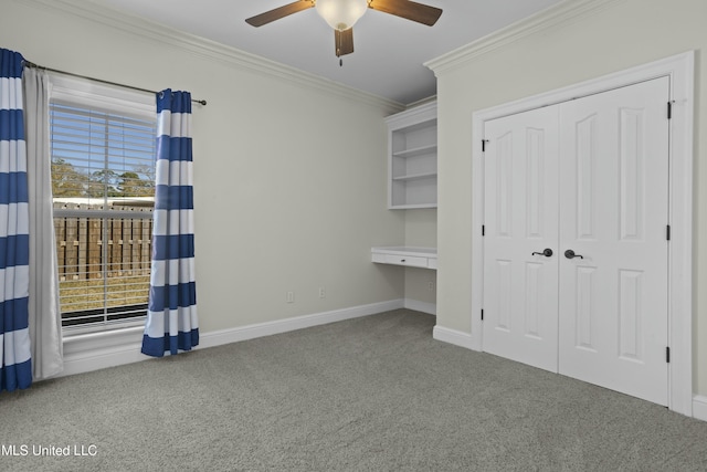 unfurnished bedroom with ceiling fan, a closet, crown molding, and carpet flooring