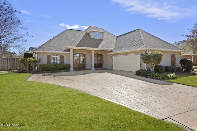 view of front of home with french doors, a garage, and a front yard