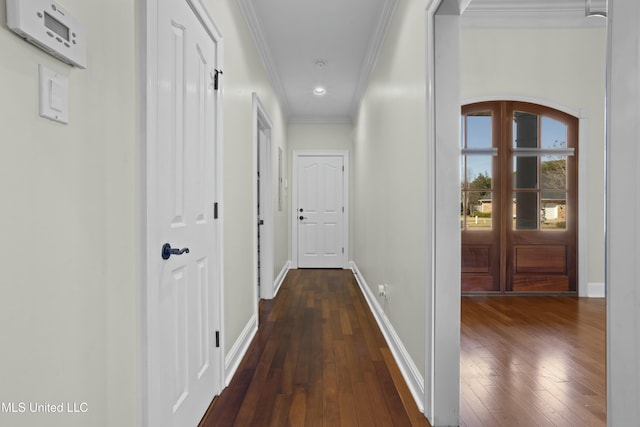 corridor featuring dark wood-type flooring and crown molding