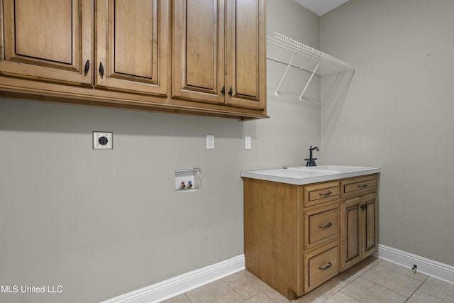 laundry room with sink, light tile patterned flooring, hookup for a washing machine, hookup for an electric dryer, and cabinets