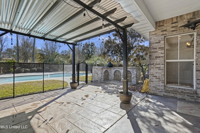 view of patio / terrace with exterior kitchen, a bar, and a fenced in pool