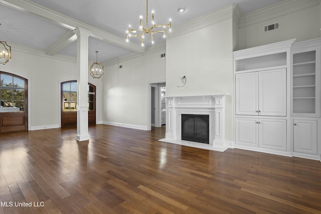 unfurnished living room with dark wood-type flooring, a high end fireplace, crown molding, and decorative columns