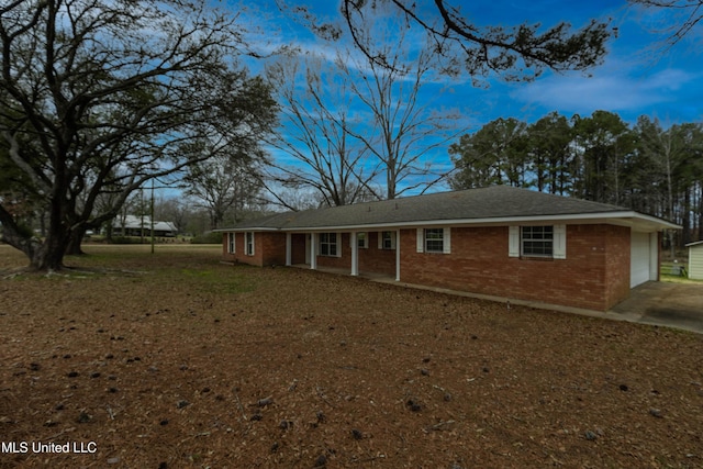 ranch-style house with an attached garage, concrete driveway, and brick siding