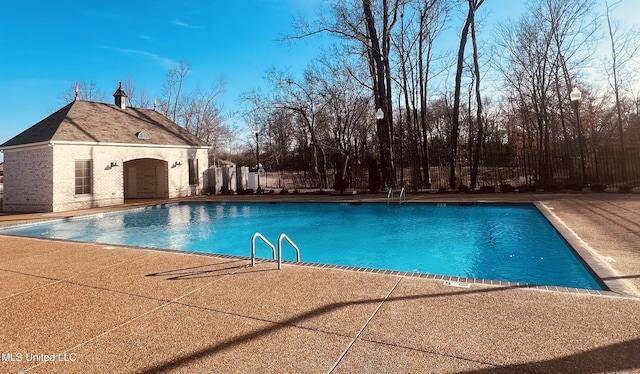 view of swimming pool with an outdoor structure and a patio