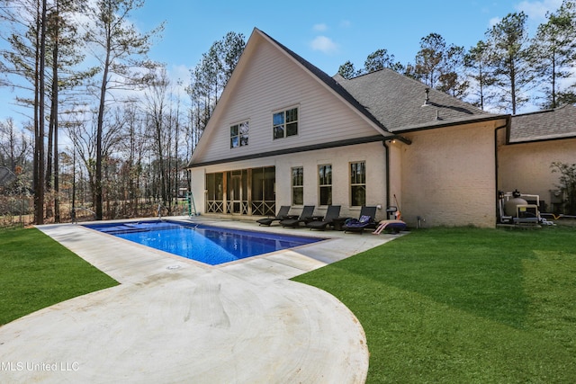 back of house featuring a yard, a sunroom, and a patio