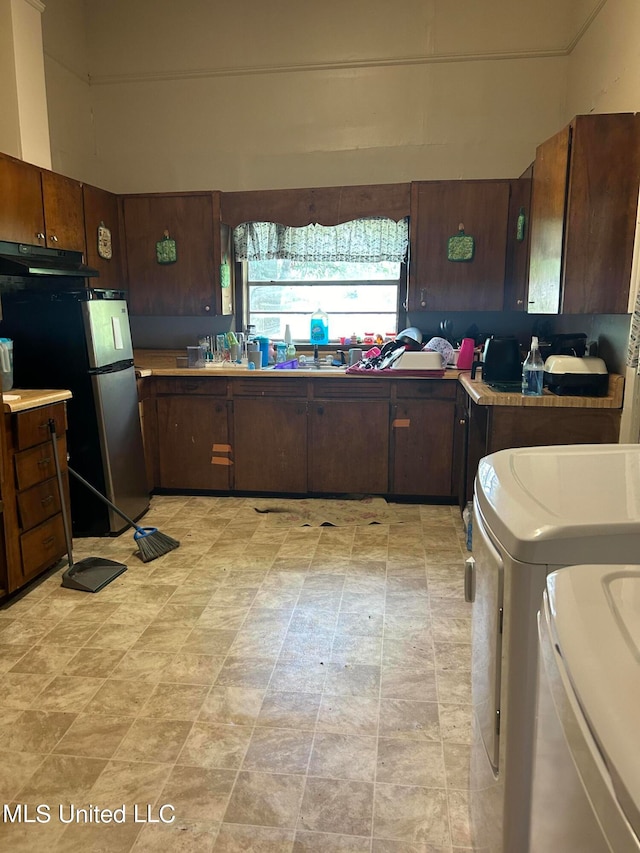 202 Dewey St, Itta Bena, MS 38941 - kitchen with independent washer and dryer, stainless steel refrigerator, and dark brown cabinetry