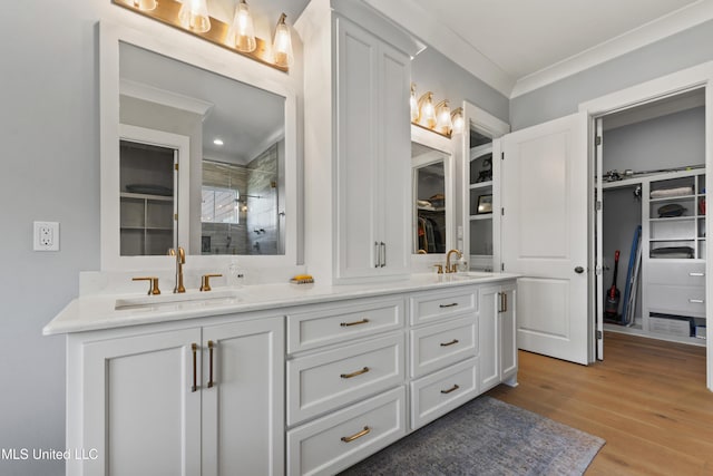 140 Seaside Dr, Ocean Springs, MS 39564 - full bath with double vanity, a stall shower, a spacious closet, wood finished floors, and crown molding