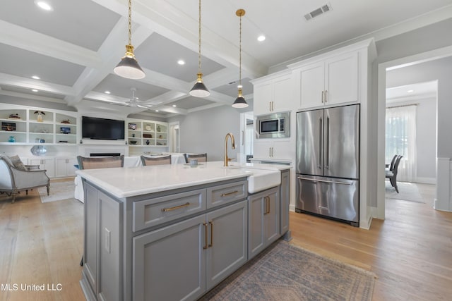 140 Seaside Dr, Ocean Springs, MS 39564 - kitchen featuring stainless steel appliances, gray cabinetry, a ceiling fan, light wood-style floors, and an island with sink
