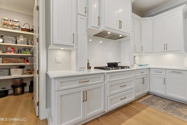 140 Seaside Dr, Ocean Springs, MS 39564 - kitchen featuring light wood-style flooring, white cabinets, crown molding, stainless steel gas cooktop, and light countertops