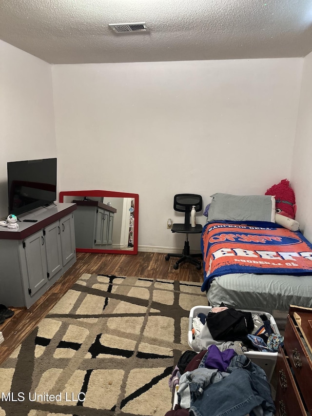 bedroom with wood finished floors and visible vents