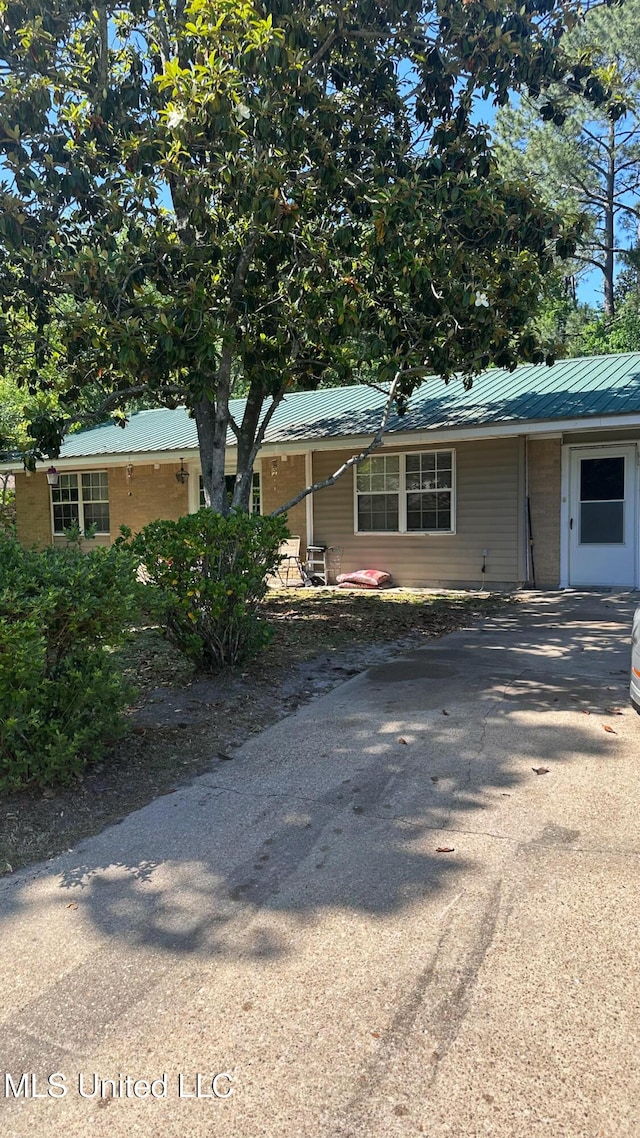 single story home featuring metal roof