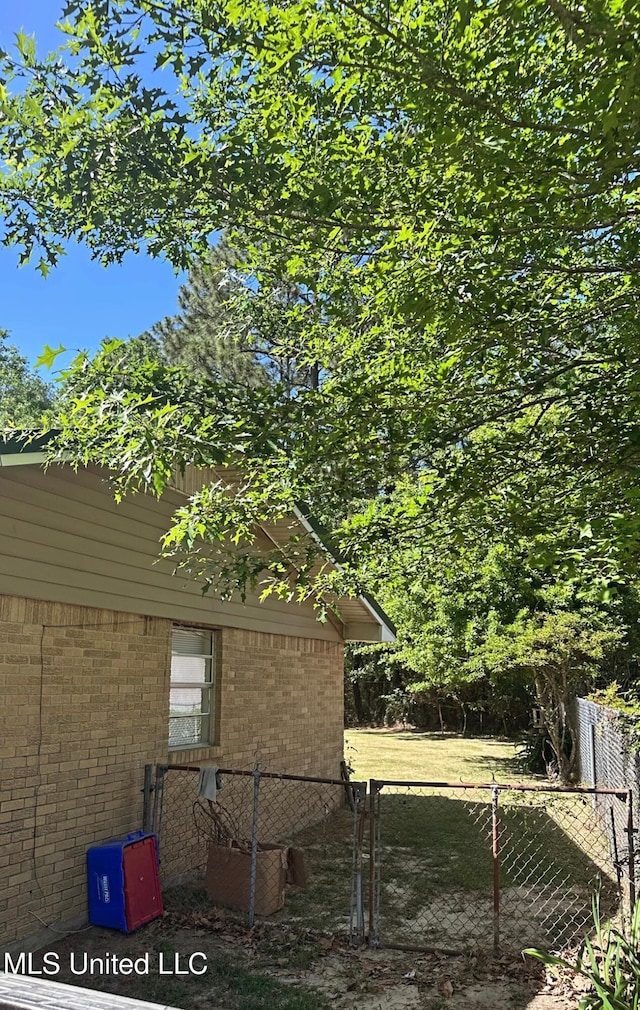 view of side of property with brick siding and fence