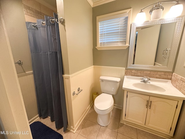 bathroom with walk in shower, toilet, vanity, crown molding, and tile patterned floors