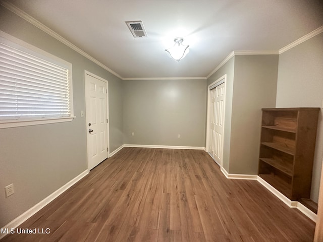 interior space with a closet, crown molding, and dark hardwood / wood-style floors