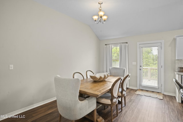12 Mercer Dr, Petal, MS 39465 - dining space with a chandelier, vaulted ceiling, dark wood-type flooring, and baseboards