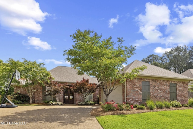 view of front of home with french doors, concrete driveway, brick siding, a front yard, and a garage