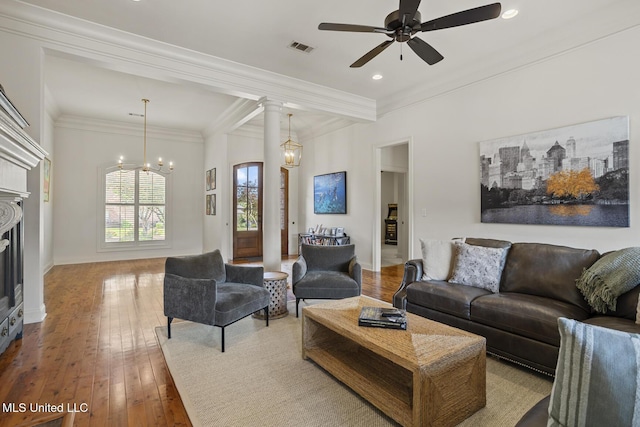 living area featuring a ceiling fan, hardwood / wood-style flooring, recessed lighting, ornamental molding, and a fireplace