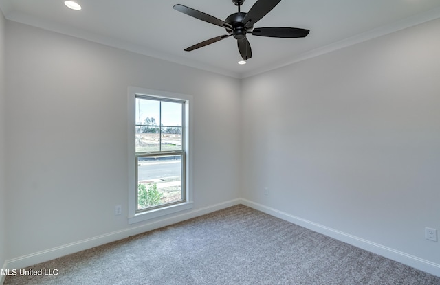 carpeted spare room with ceiling fan, a wealth of natural light, and crown molding