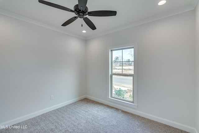 carpeted spare room with ceiling fan and ornamental molding