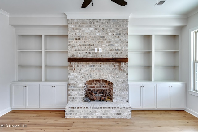 unfurnished living room featuring a brick fireplace, ceiling fan, and light wood-type flooring