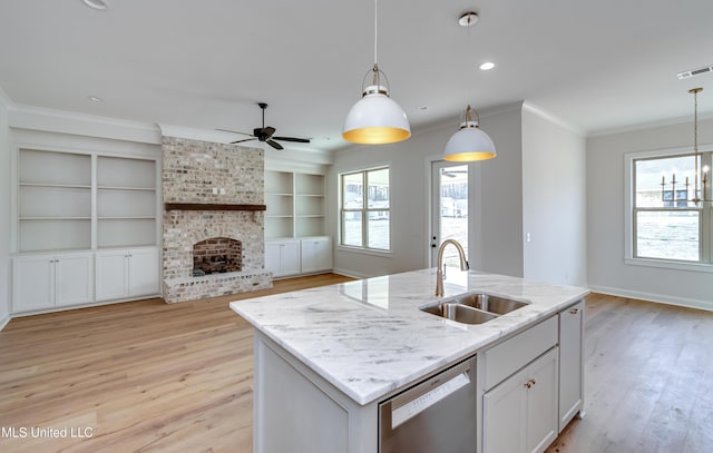 kitchen with pendant lighting, dishwasher, white cabinetry, sink, and built in features