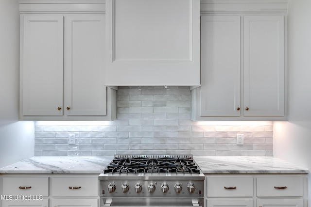 kitchen with white cabinetry, decorative backsplash, and stainless steel range