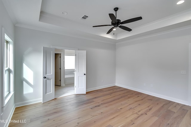 unfurnished room with ceiling fan, a raised ceiling, light hardwood / wood-style flooring, and crown molding