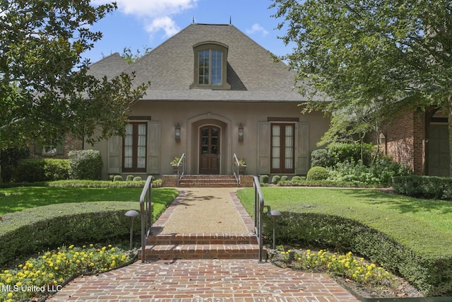 french country style house with a front lawn and french doors