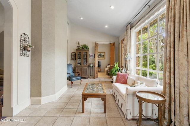 living area with light tile patterned floors and vaulted ceiling