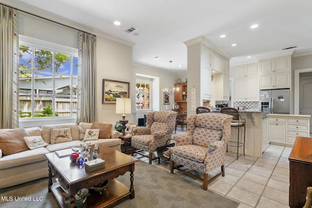 living room with light tile patterned floors, a notable chandelier, and crown molding