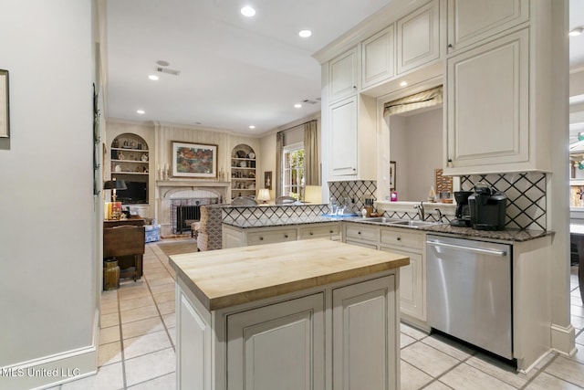 kitchen with tasteful backsplash, dishwasher, butcher block countertops, kitchen peninsula, and built in shelves