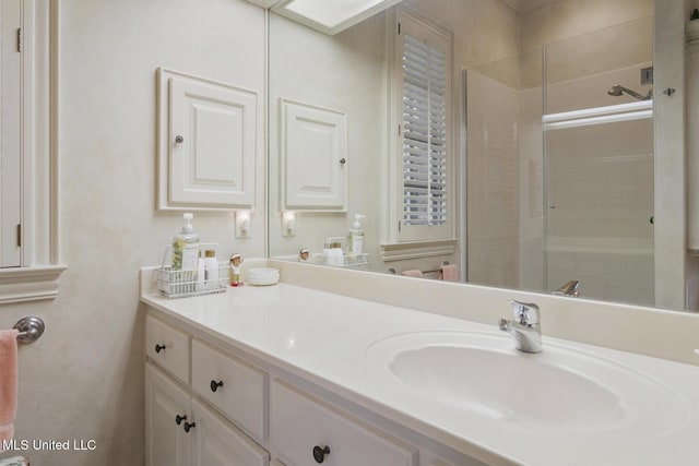 bathroom featuring vanity and a shower with door