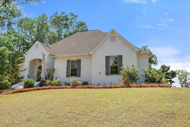 view of front of home featuring brick siding and a front yard