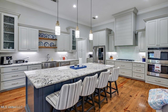 kitchen with decorative backsplash, a kitchen island, appliances with stainless steel finishes, a sink, and recessed lighting
